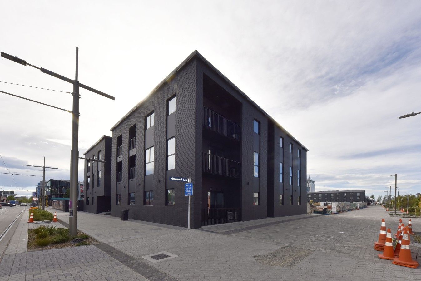 Un edificio moderno con tetto piatto, ampie finestre e una segnaletica che indica uno spazio pubblico.