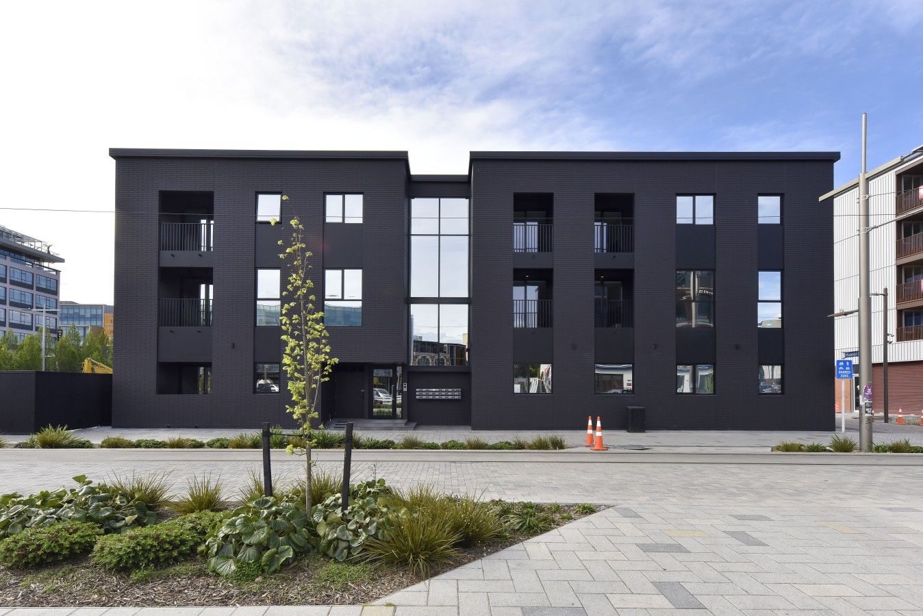 A modern building with a flat roof, rectangular windows, and a symmetrical facade.