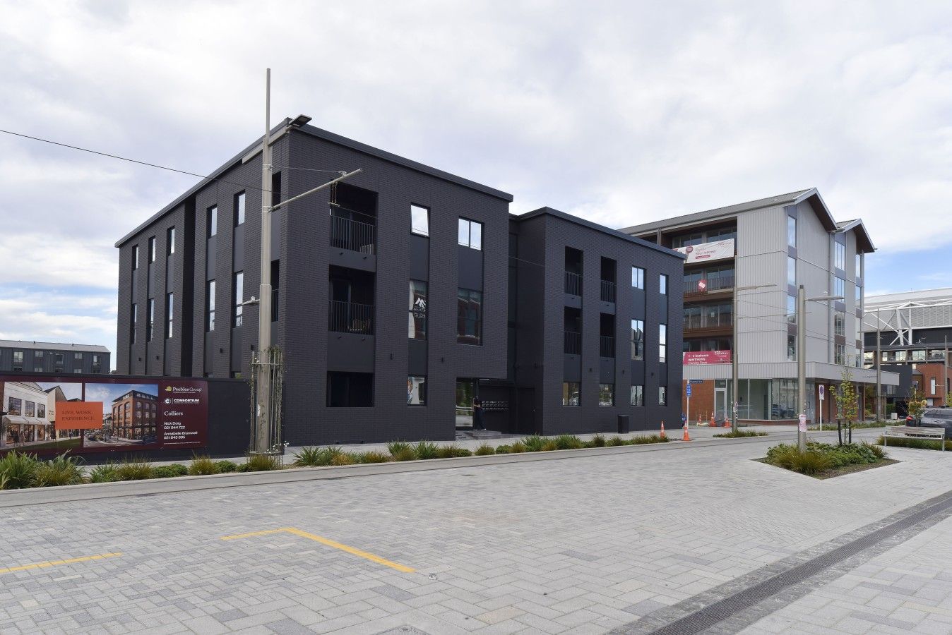 A modern building with a flat roof, multiple windows, and a visible entrance.