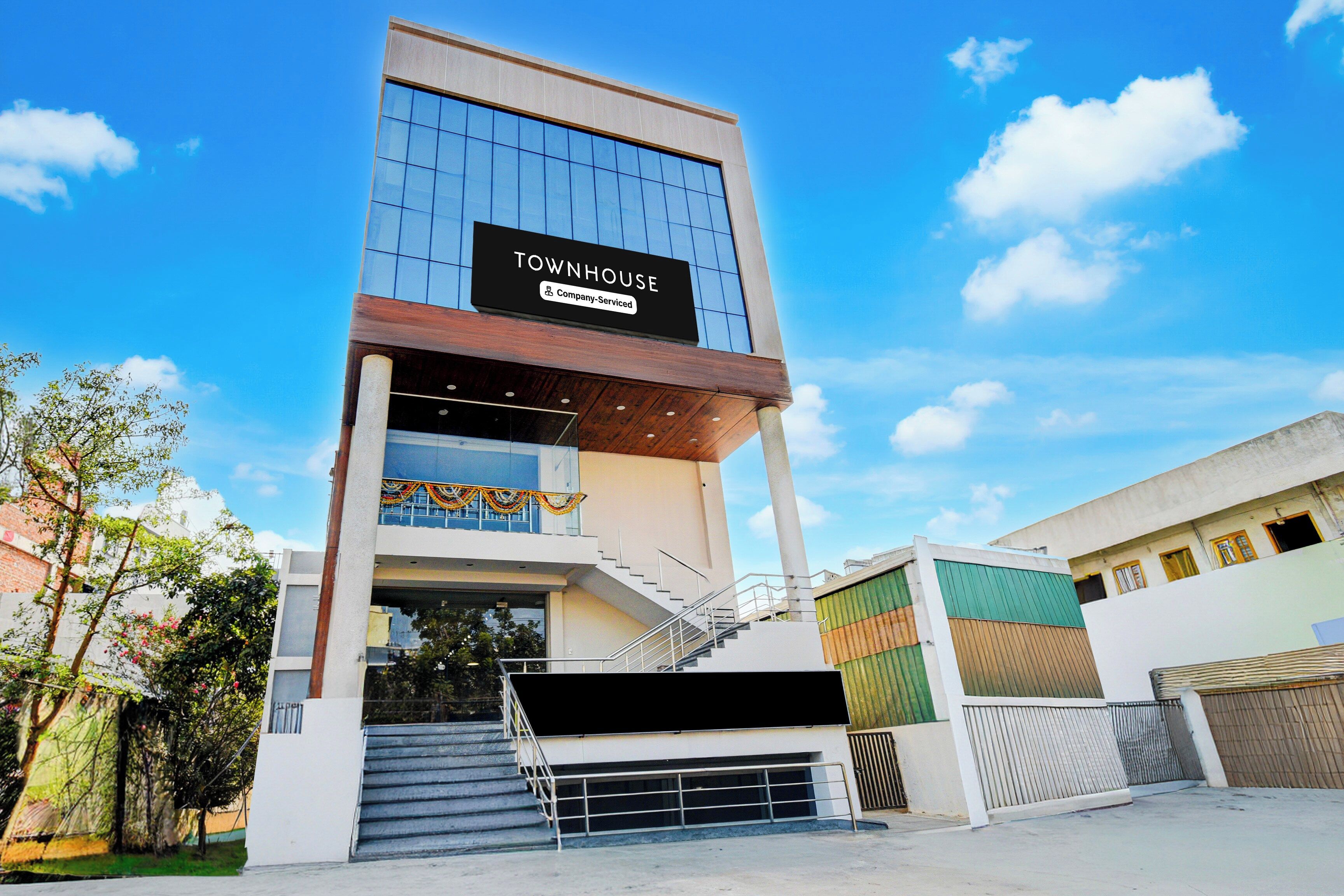 A multi-story building with a sign reading 'TOWNHOUSE Company-Serviced.'