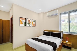 A bedroom with a bed, a nightstand, a window, and three wall-mounted artworks. - Townhouse Suchitra IDA Jeedimetla (Hyderabad)