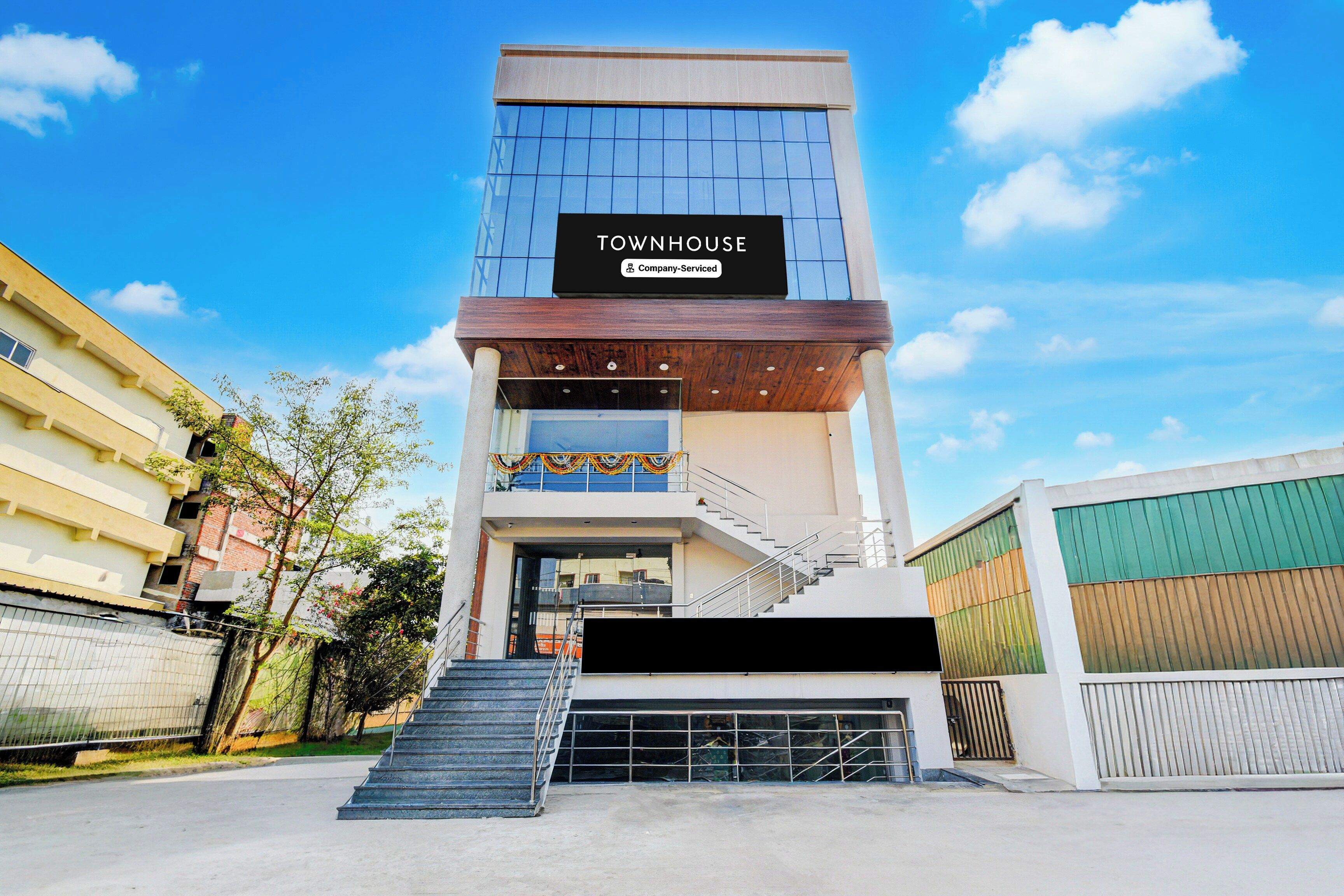 Un edificio de varios pisos con un letrero que dice 'TOWNHOUSE Company-Serviced'.