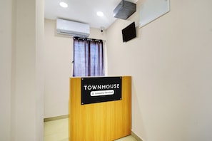 Una mesa de recepción con la etiqueta 'TOWNHOUSE' y un letrero que indica que ofrece servicios de empresa.