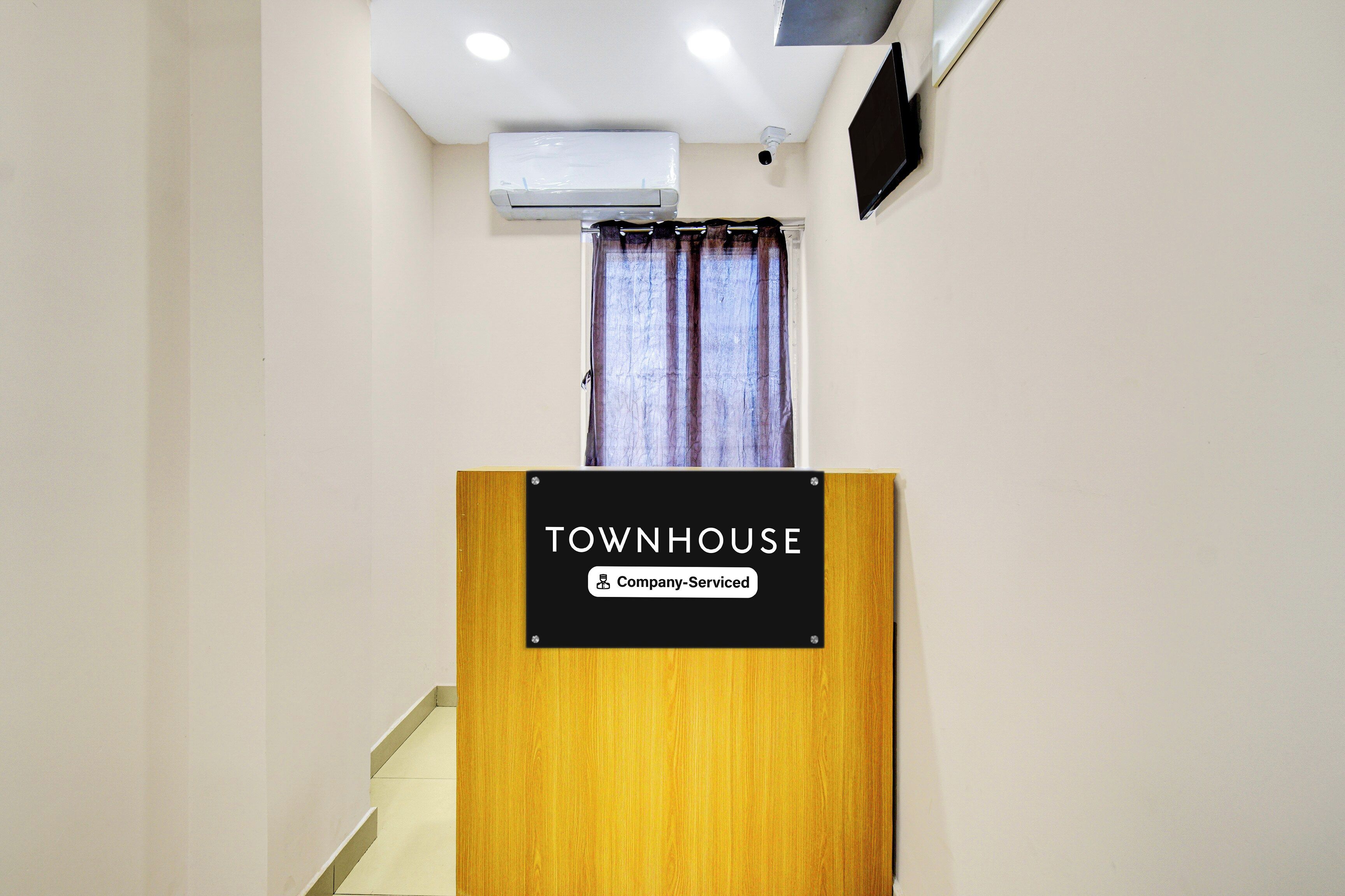 A wooden podium with a sign that reads 'TOWNHOUSE Company-Serviced.'