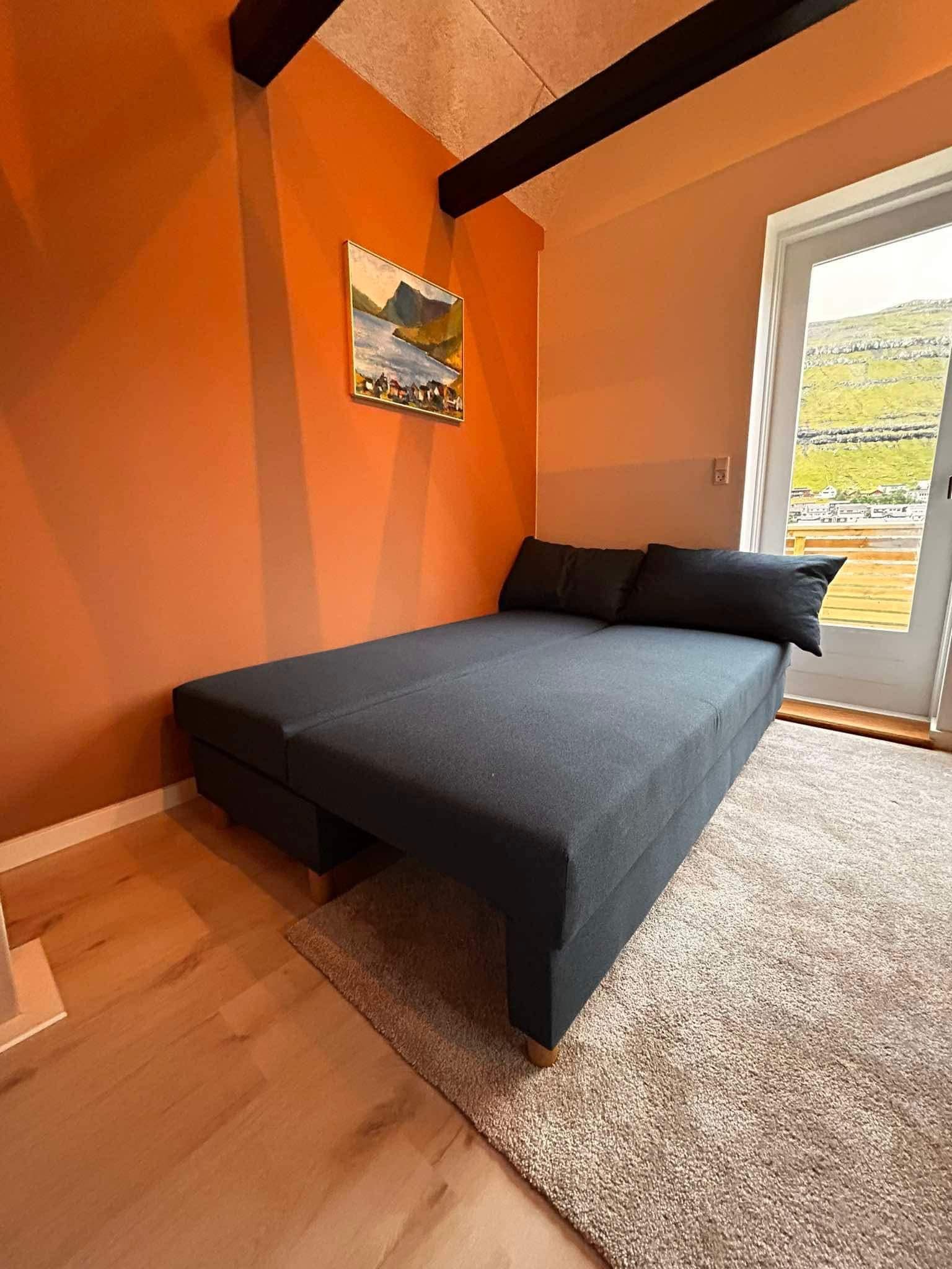Une chambre à coucher avec un lit, un tableau et une vue par la fenêtre.