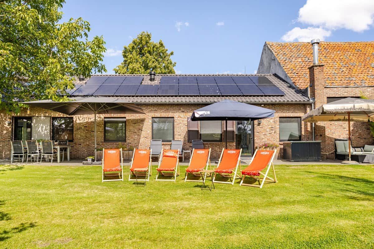 A building with a brick facade, a tiled roof, and a solar panel array.