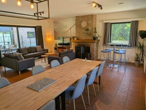 A spacious living area with a fireplace, a dining table, and comfortable seating.