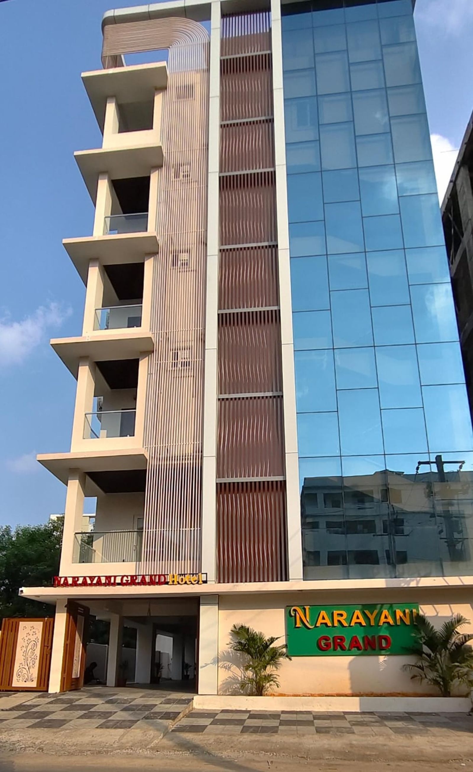 Un edificio de hotel con fachada moderna, varios balcones y un letrero llamativo para Narayan Grand Hotel.