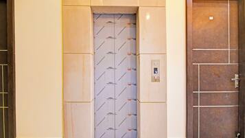 An elevator with a patterned wall and a control panel.