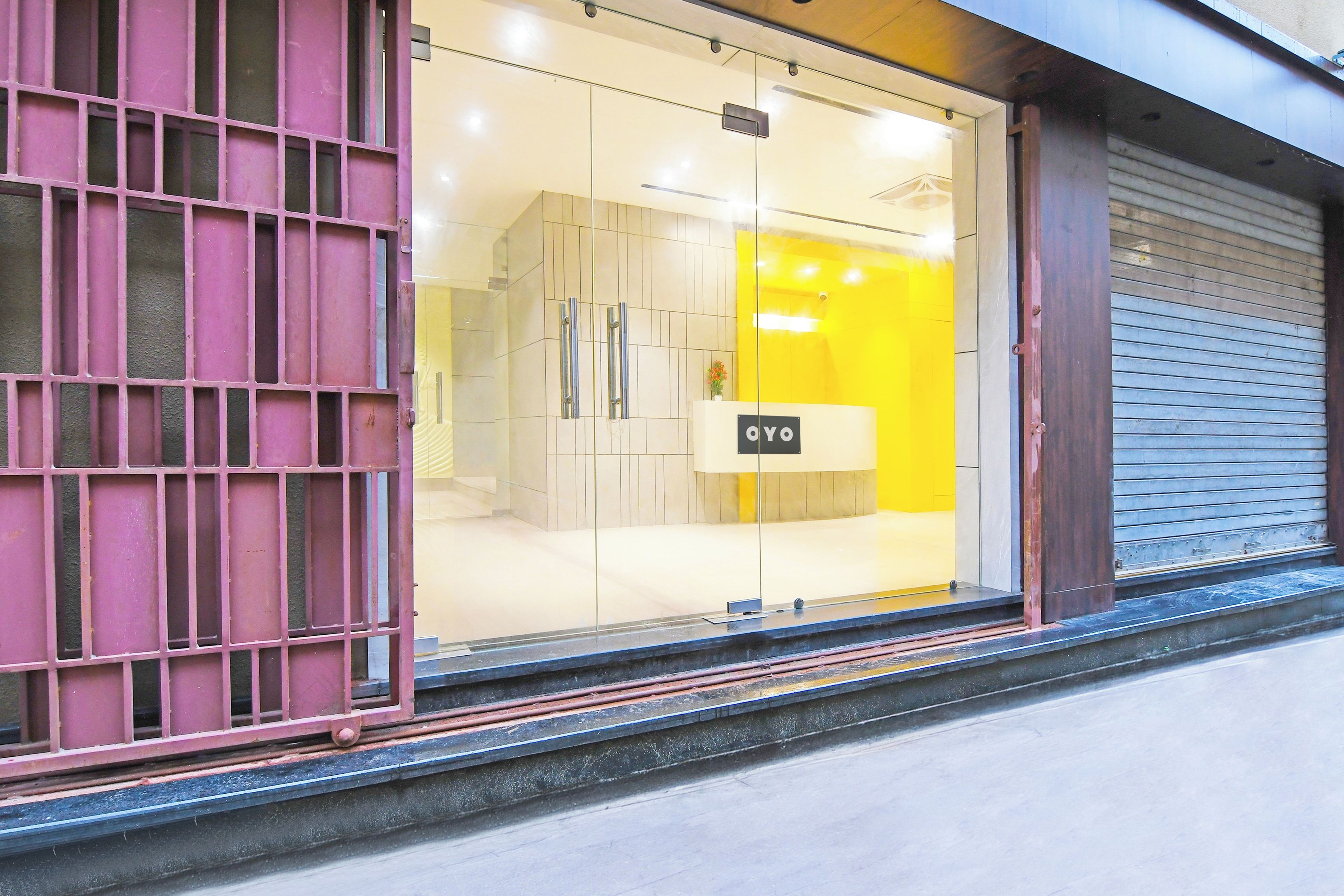 Un escaparate con fachada de vidrio, una puerta metálica y un cartel con las letras 'OYO'.