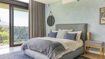 Una camera da letto moderna con un letto grande, vista sull'esterno e condizionatore d'aria a muro.