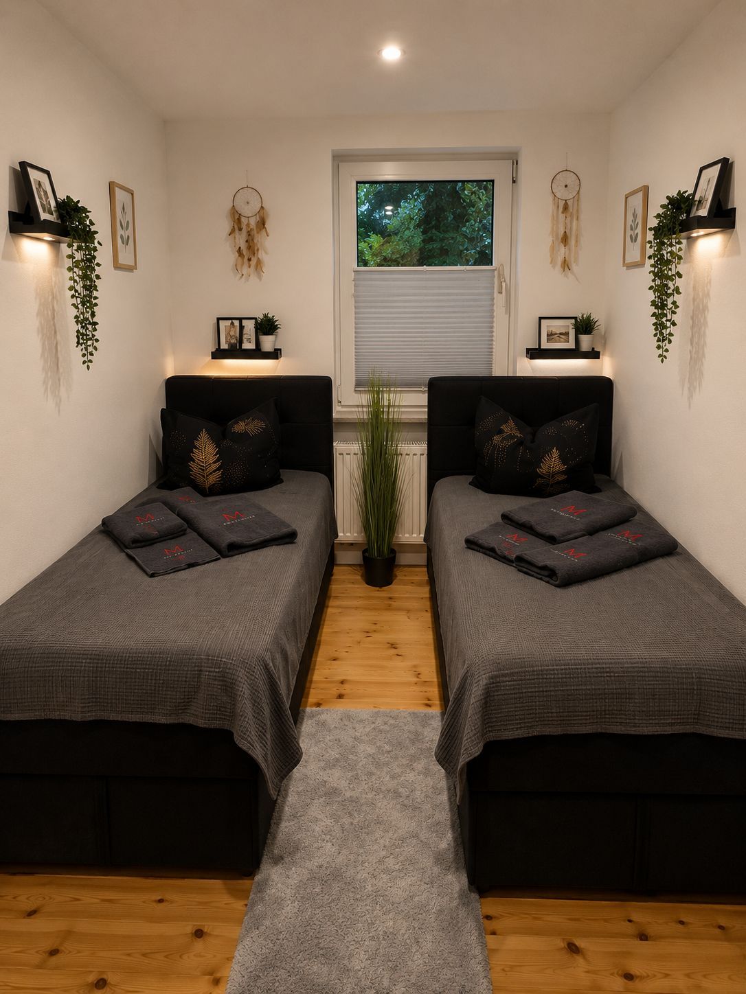 A bedroom with two single beds, a window with blinds, and a radiator.