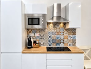 A kitchen with a microwave, a coffee machine, and a patterned backsplash. - The advantages of a detached house with services and quality of a boutique hotel (Il-Belt Valletta)