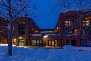 A brick building with a central courtyard, a bench, and a sign that reads 'Hotel'. - 2BR Winter Wonderland (Park City)