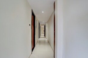 A long, narrow hallway with doors on both sides, leading to rooms.