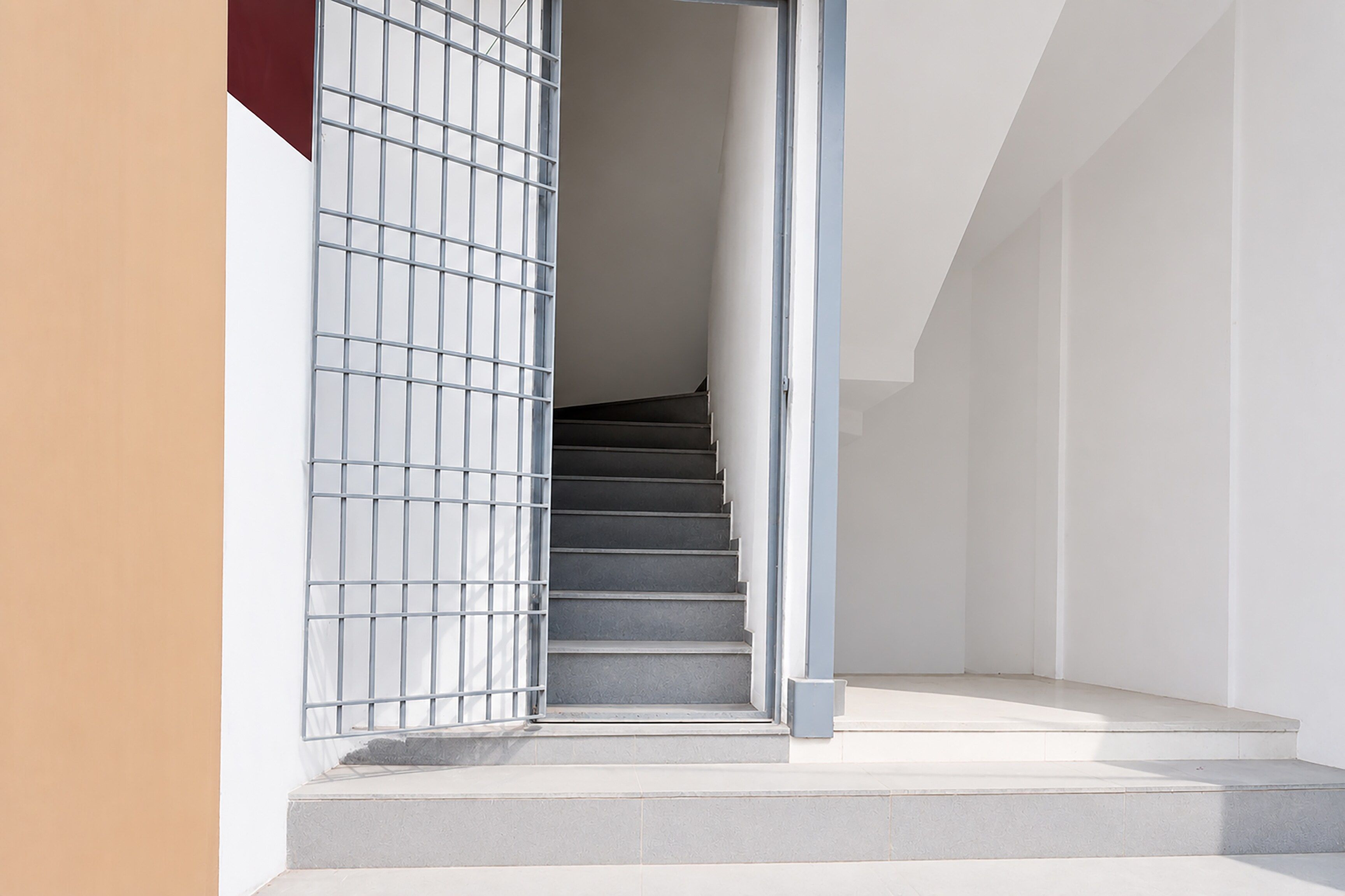 A staircase leading to a landing with a metal gate on the left.