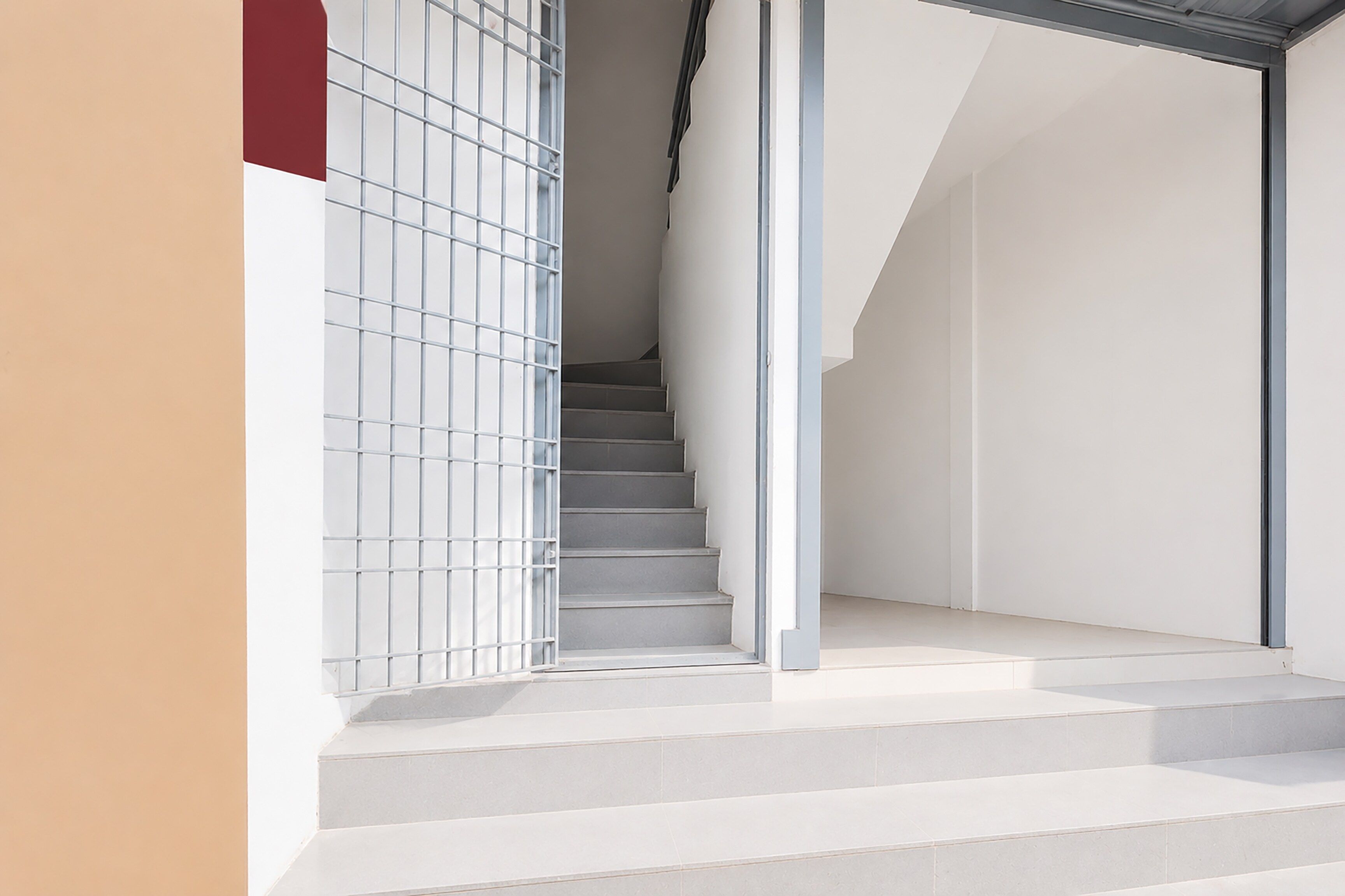 A staircase leading to a landing with a metal railing on one side.