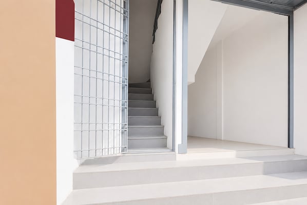 A staircase leading to a landing with a metal railing on one side.