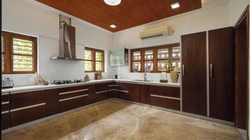 A modern kitchen with wooden cabinets, a central island, and a built-in stove.
