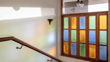 Una escalera de madera con barandilla de vidrio que lleva a una plataforma.