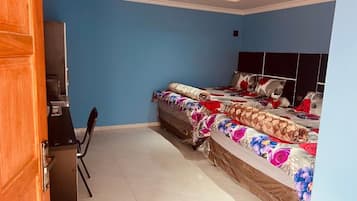 Una camera da letto con due letti, una scrivania e una sedia.