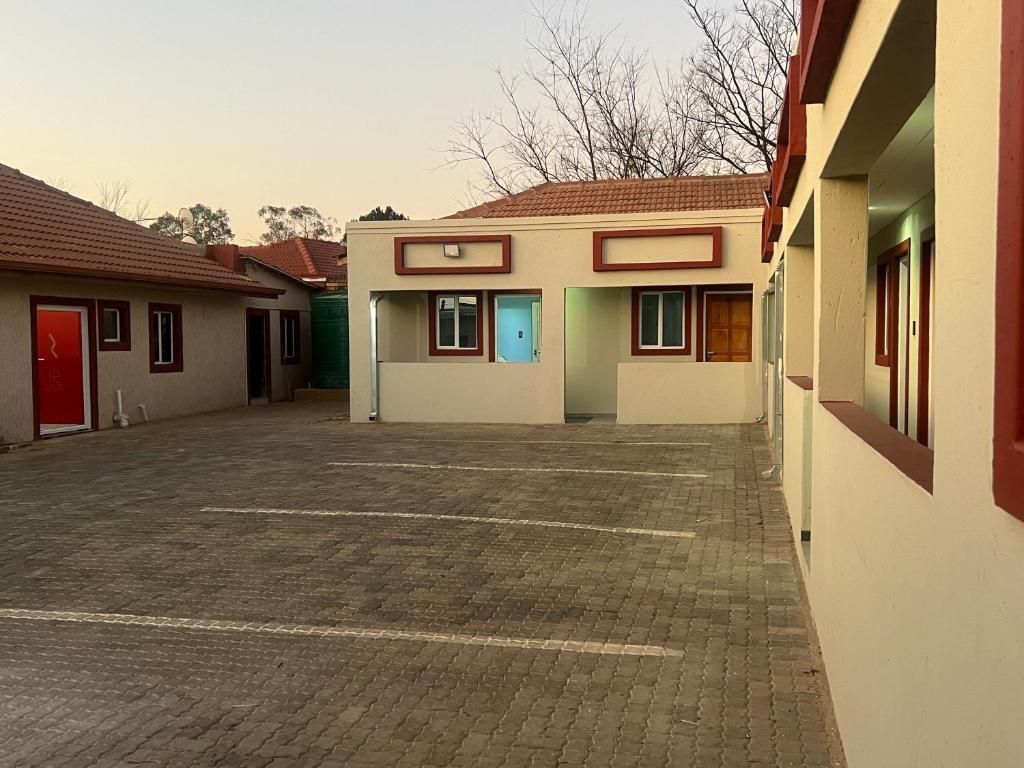 Un edificio con diverse stanze, un'area centrale aperta e una porta rossa.