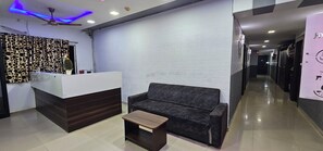 Un área de recepción con mostrador, un sofá y una pequeña mesa.