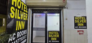 A hotel entrance with signs indicating 'Hotel Silver Inn AC Rooms' and a directional arrow pointing to the right. - Hotel Silver Inn (Ahmedabad)