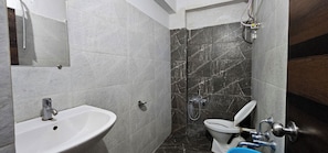 Un baño con lavamanos, inodoro y zona de ducha.
