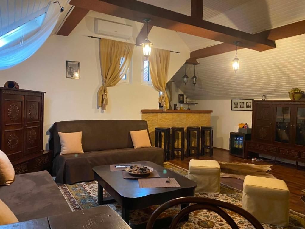 Una sala acogedora con sofá, una mesa de centro y un comedor con sillas y una barra.