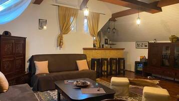 Una sala acogedora con sofá, una mesa de centro y un comedor con sillas y una barra.