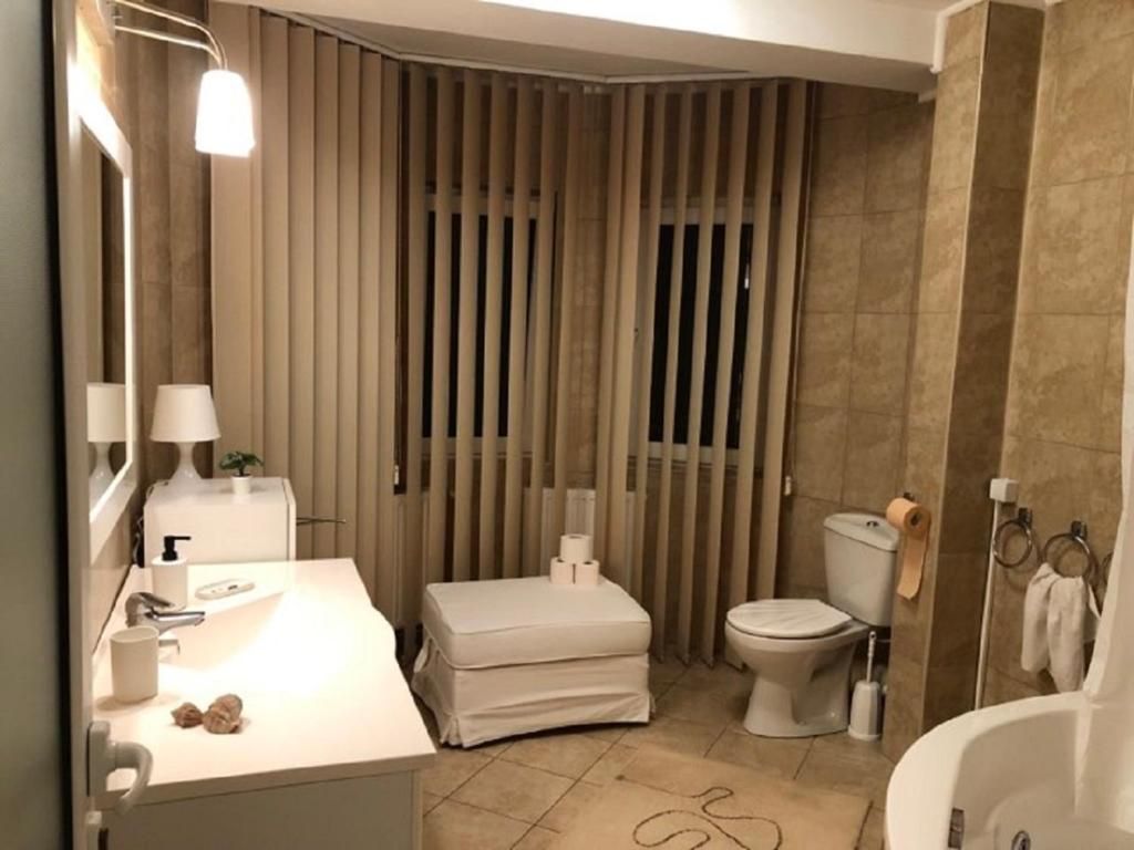 Een moderne badkamer met een wastafel, toilet en douchehoek.