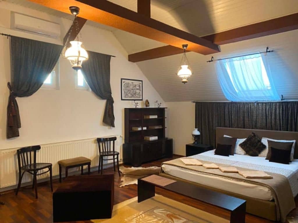 Un dormitorio con una cama grande, un banco de madera, una mesita de noche y una estantería.