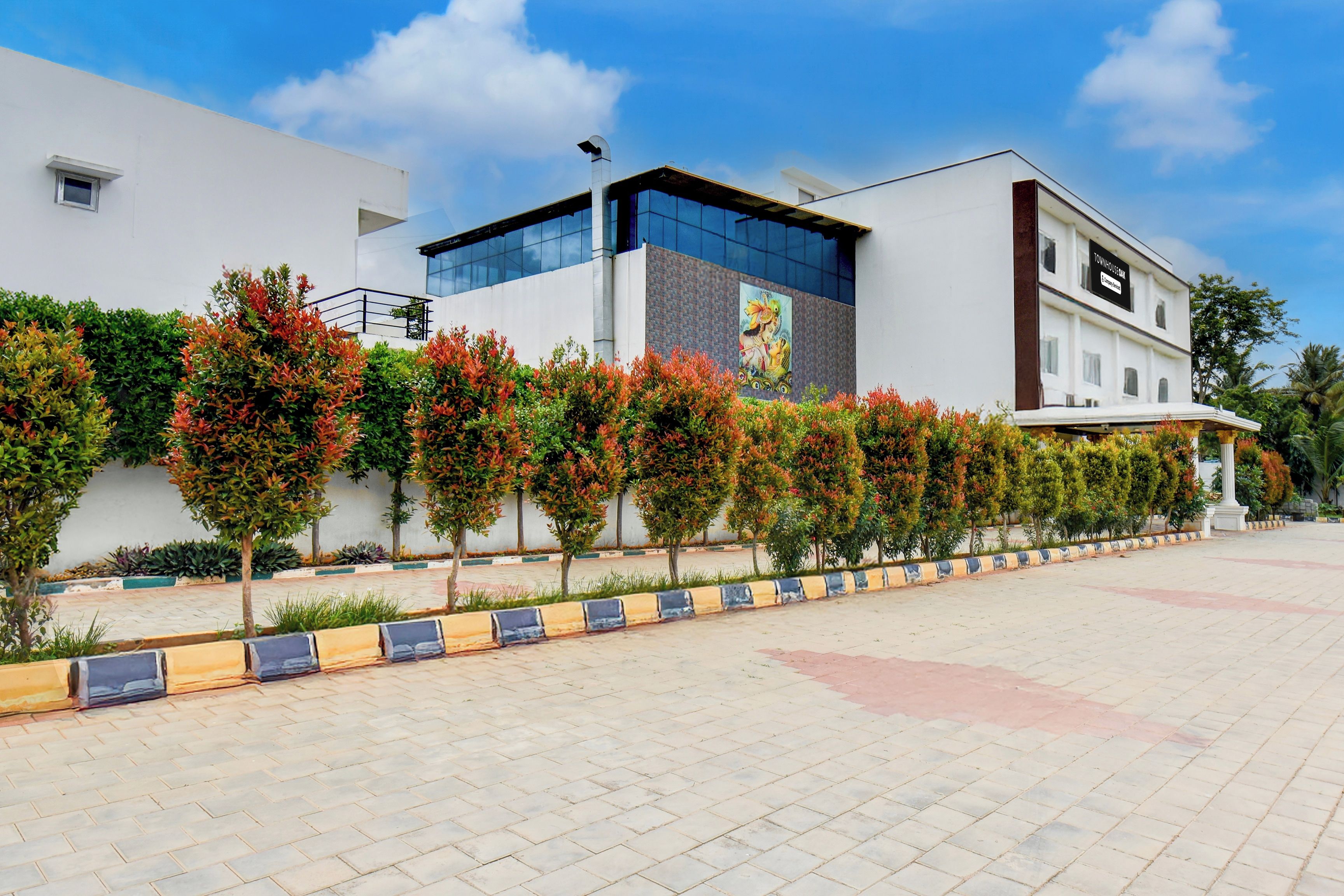 A modern building with a flat roof, a large glass facade, and a sign indicating it's a townhouse.