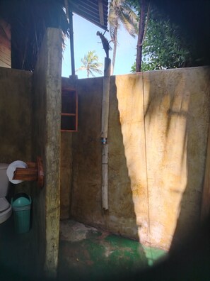A small, enclosed bathroom with a toilet, a wooden door, and a visible pipe. - New Listing (Córdoba)