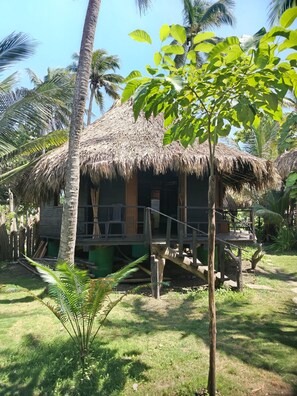 A thatched-roof hut with a wooden deck and a staircase leading to a raised platform. - New Listing (Córdoba)