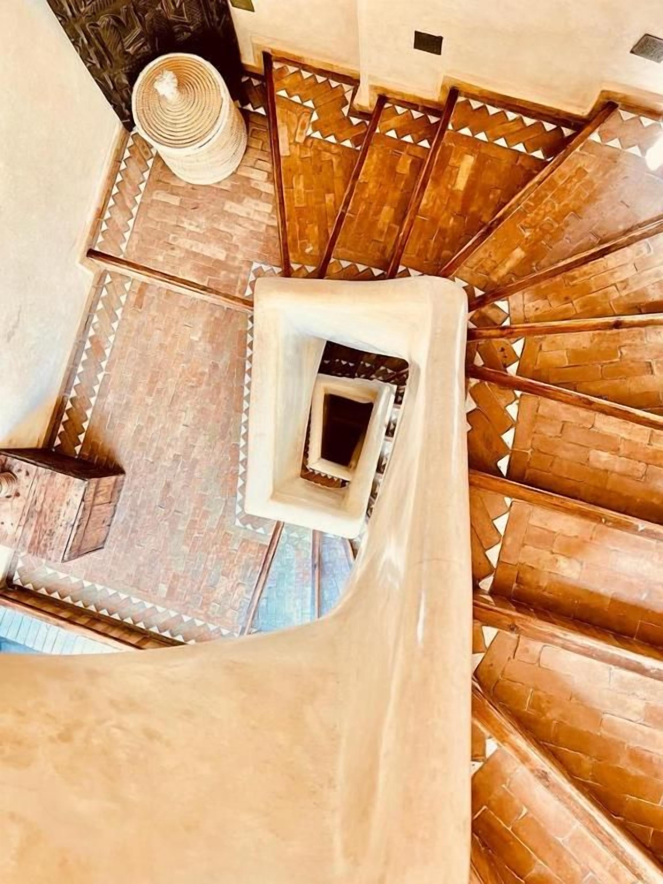 A spiral staircase with a view of a room below.