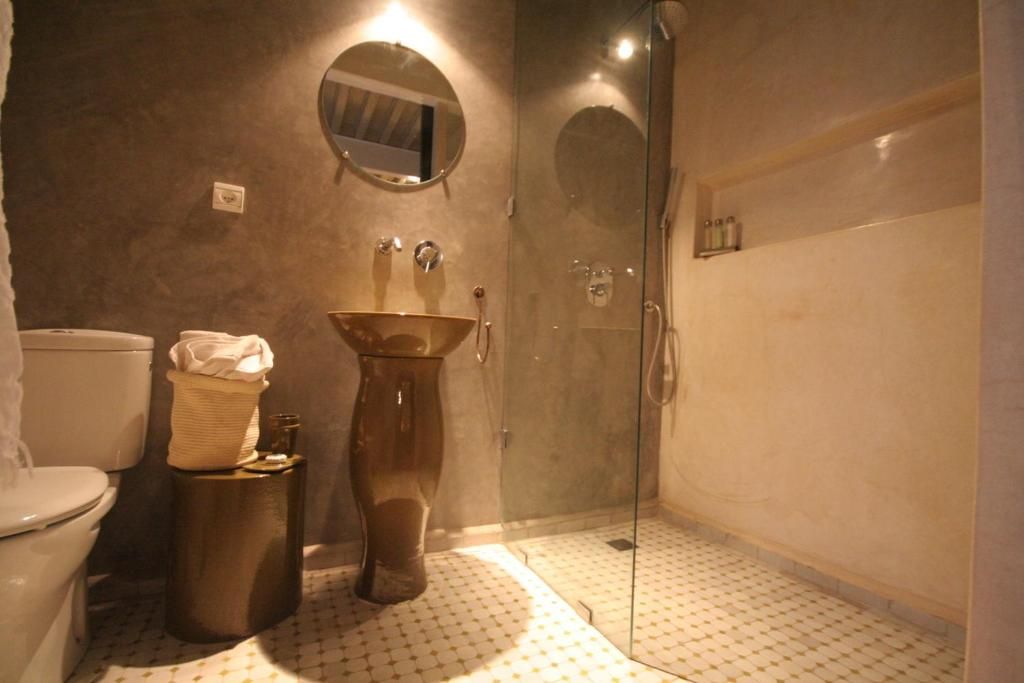 Un baño con inodoro, lavabo y zona de ducha.