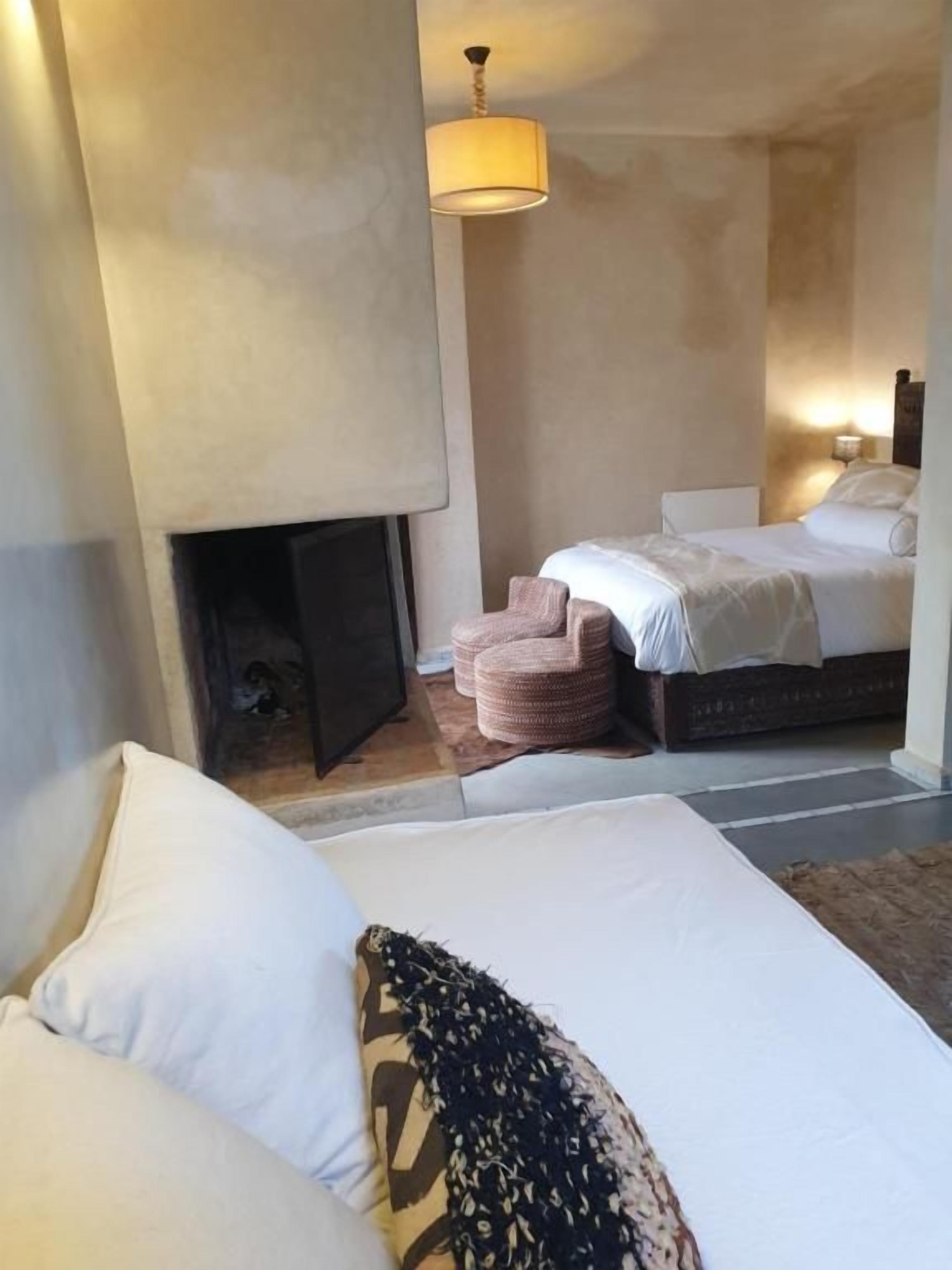 Un dormitorio con una cama, chimenea y mesita de noche.