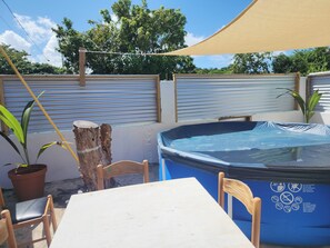 A hot tub with a blue cover, a white table, and two wooden chairs. - Nice Place to Relax Leve I (Fajardo)