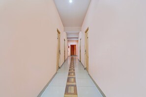 Un pasillo con puertas a ambos lados que conduce a una habitación al final.