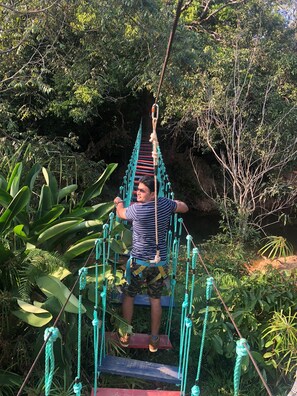 A person on a rope bridge in a natural setting. - Streamedge Resort (Sakleshpur)