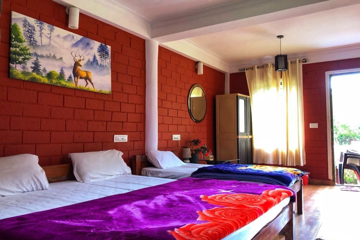 A hotel room with two beds, a painting of a deer, a mirror, and a view of the outdoors.