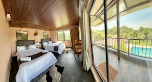 A hotel room with two beds, a balcony with a view of a swimming pool, and a wooden ceiling. - Streamedge Resort (sakleshpur)