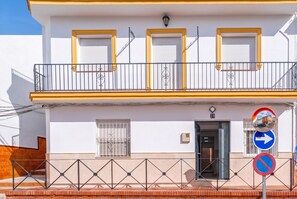 A two-story building with a balcony, a door, and a no parking sign. - Cubo's Casa La Roca / urban / air conditioning / terrace / free Wi-Fi (Alhaurín el Grande)