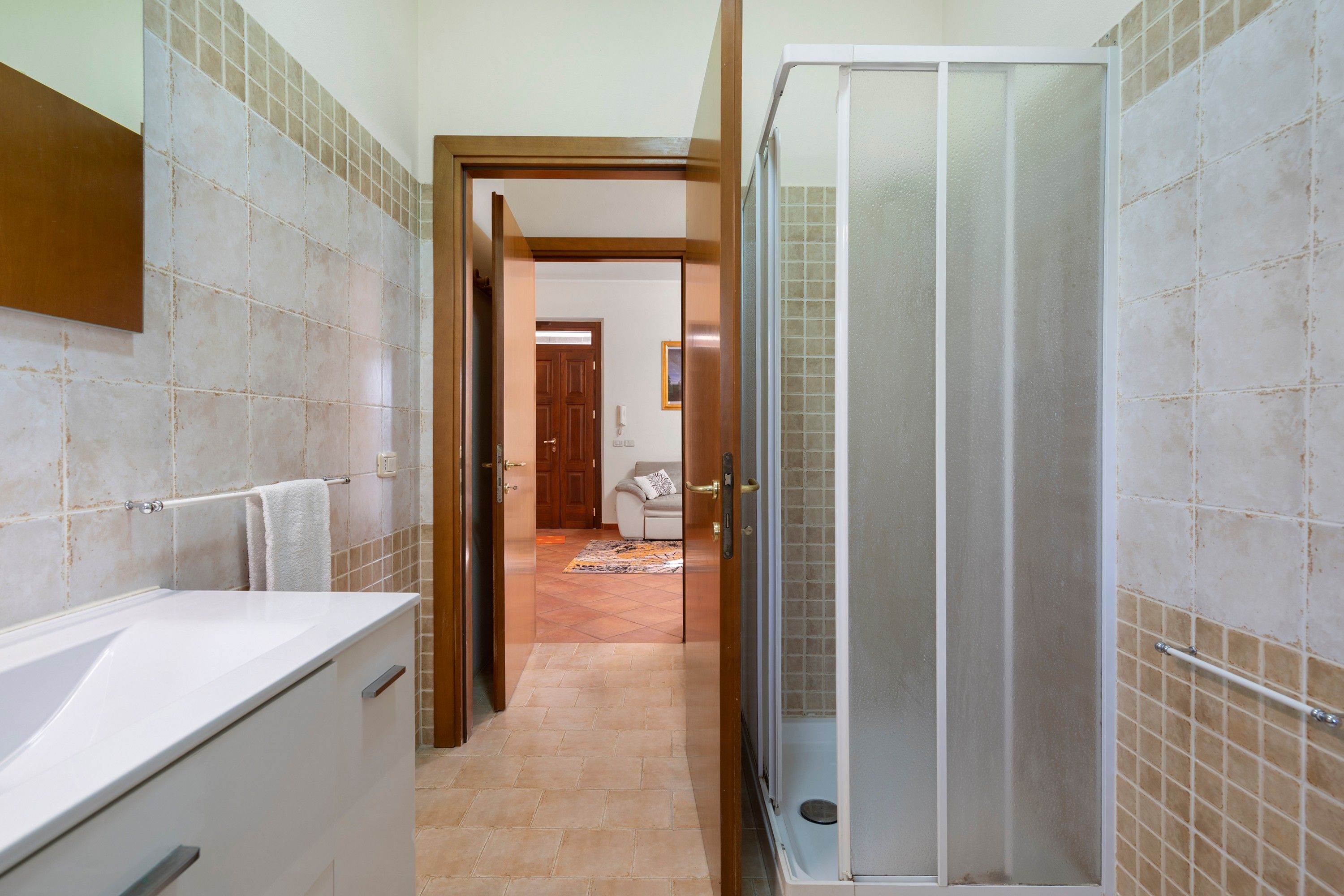 Une salle de bain avec une douche, un lavabo et un porte-serviettes.