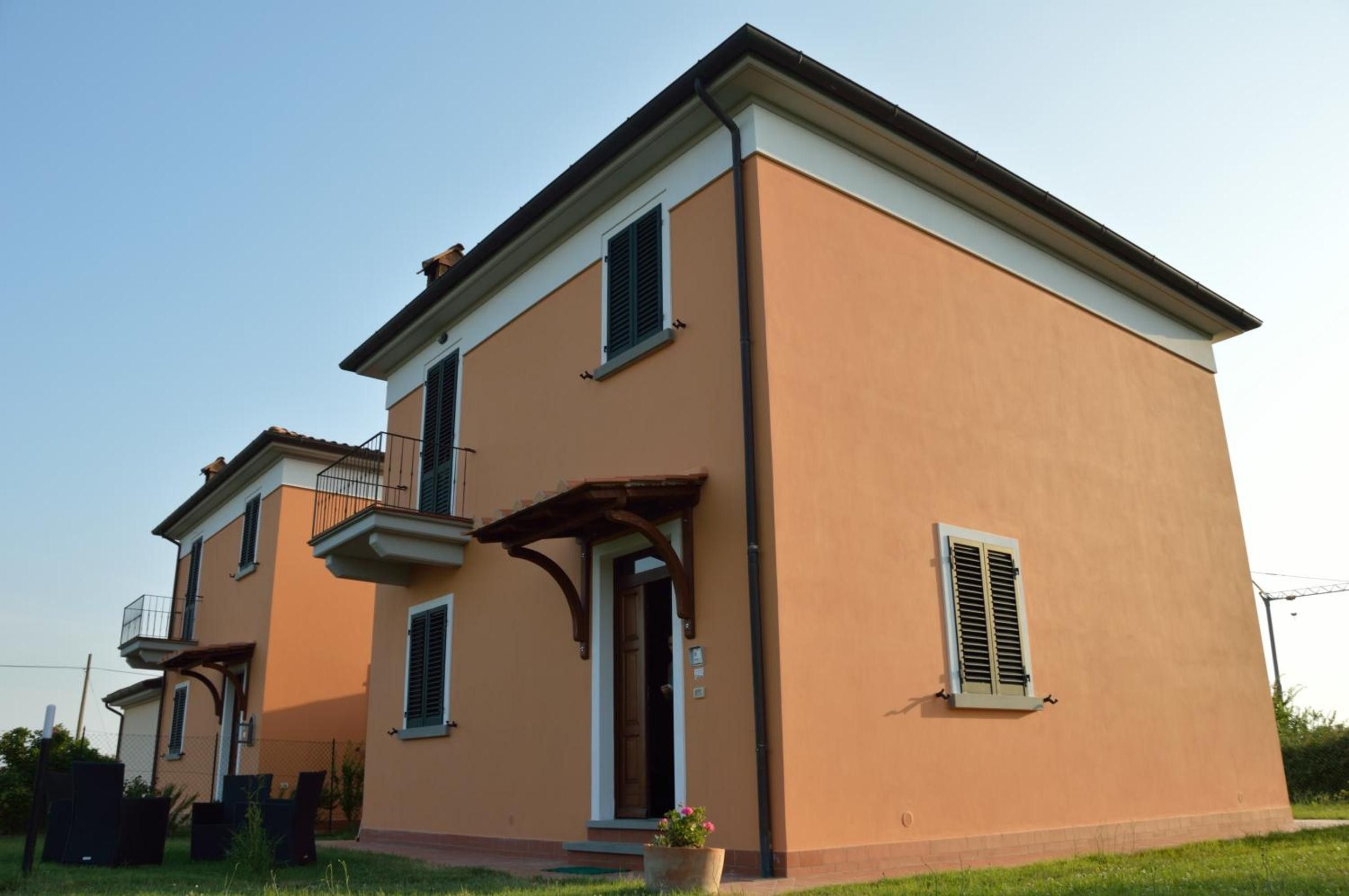 A two-story residential building with a balcony and a small porch.