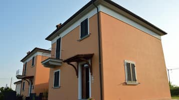 A two-story residential building with a balcony and a small porch.