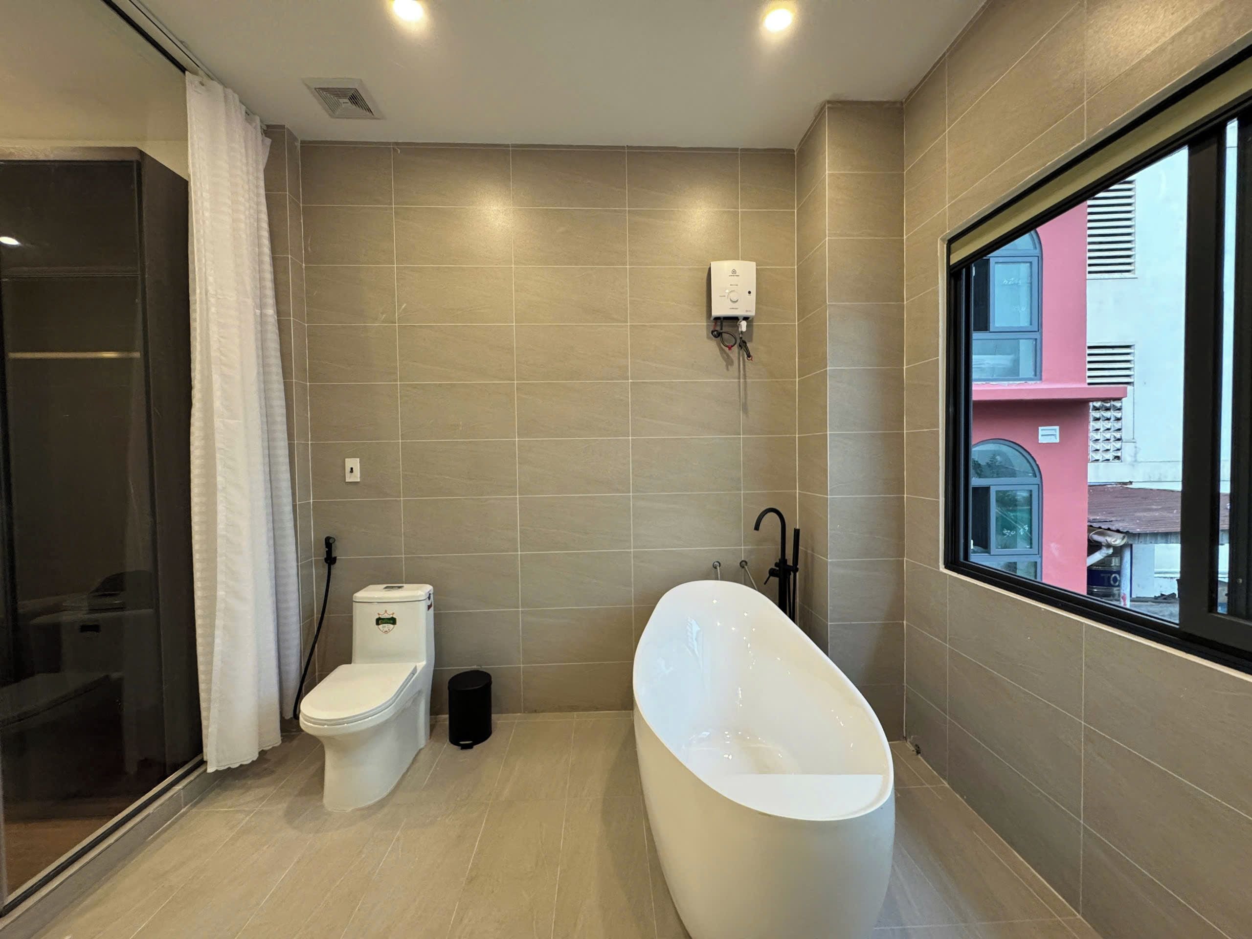 A modern bathroom with a toilet, bidet, and bathtub.