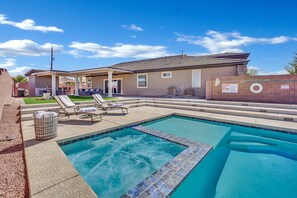A swimming pool with lounge chairs and a covered patio area. - The Reserve | Modern 5BR Henderson Pool Home (Henderson)